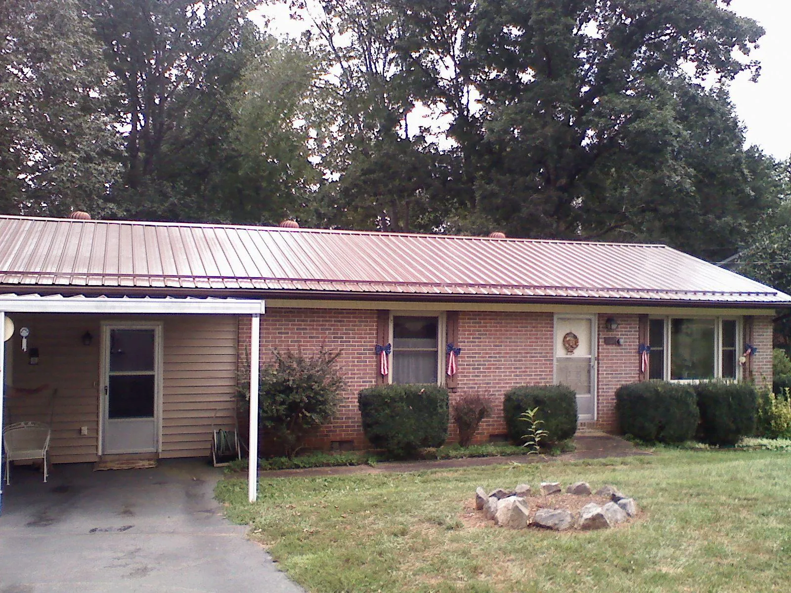 Bronze metal roof and carport on a brick ranch home — Roof Repair work by our crew in West Harrison
